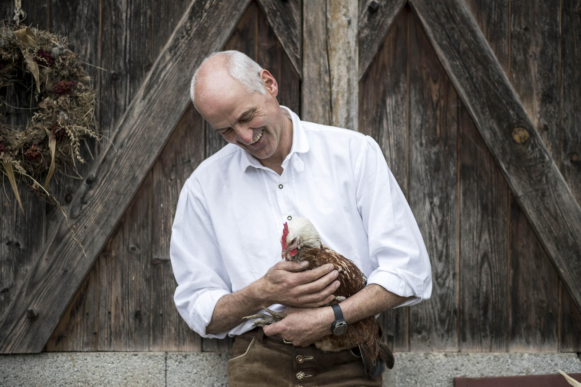 Bauer mit Huhn auf dem Arm